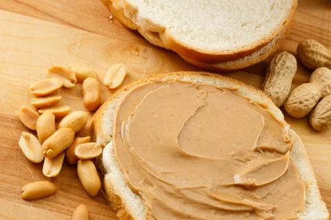 Peanut Butter on Bread with Peanuts Stock Photos