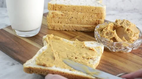 Peanut Butter on fresh slice of bread with glass of milk, zoom in close up on 스톡 동영상 61441317