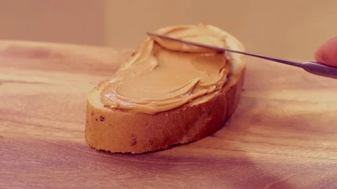 Peanut butter paste spread on bread in slow motion Stock Footage 76916158