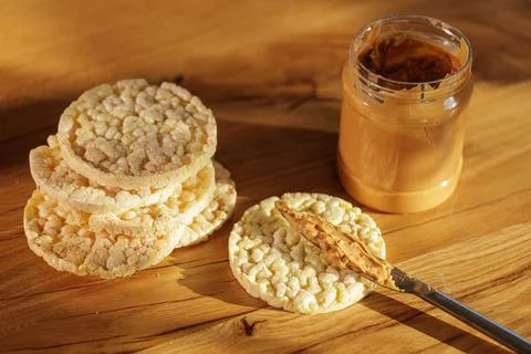 Peanut Butter Spread On Crispy Rice Cakes In Warm Light Stock Photos