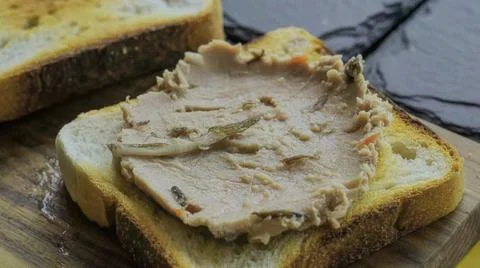 Peanut butter spread on a slice of bread placed on a wooden cutting board Stock Photos
