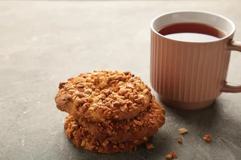 Peanut cookies with tea on grey background. Bakery products. Stock Photos