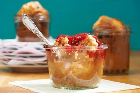 A peanut muffin with raspberry jam in a jar with a bite taken out Foto stock