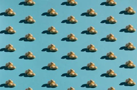 Peanut pattern with shadows on teal background. Flat lay. Minimalistic concept. Stock Photos