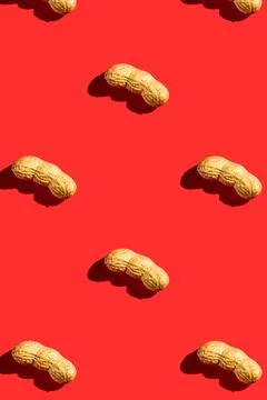 Peanut pattern with shell on red background, colorful flat lay food texture.. Stock Photos