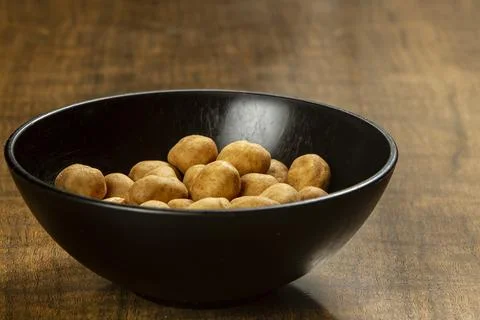 Peanut snack in a black bowl Stock Photos