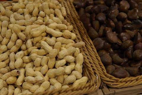 Peanuts and chestnuts in a wicker basket 스톡 사진