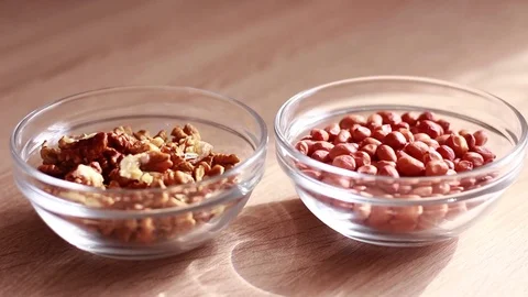 Peanuts and walnuts in glass plates Vídeo Stock 81584571
