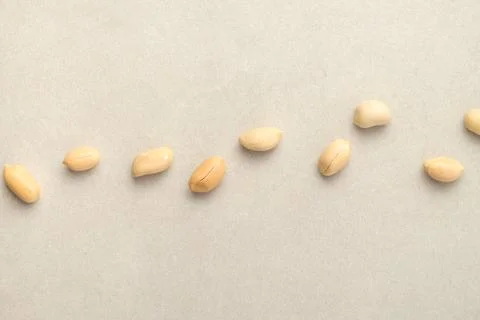 Peanuts arranged creatively on a light gray surface Stock Photos