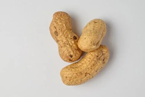 Peanuts arranged gracefully on a clean white surface Stock Photos