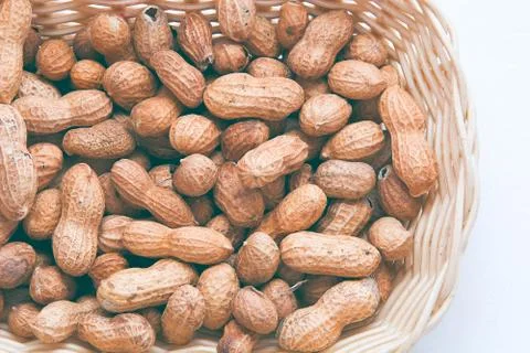 Peanuts in the basket on white backround. Stock Photos