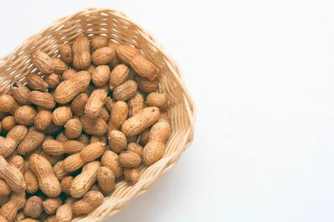 Peanuts in the basket on white backround. Stock Photos
