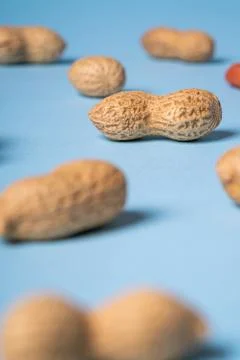 Peanuts on blue background, macro, selective focus Stock Photos