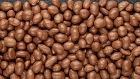 Peanuts in chocolate on a black background, top view. Stock Footage 150066325