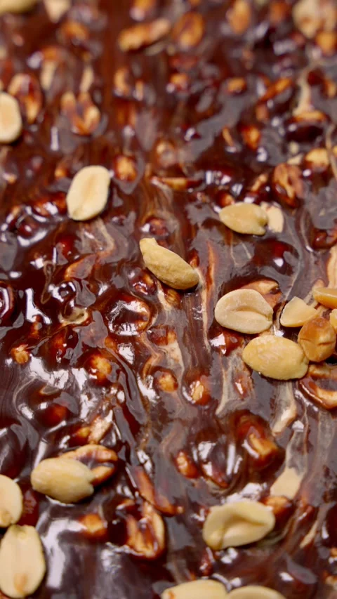 Peanuts in chocolate glaze with caramel notes. Chocolate dessert with scattered Stock Footage 274990583