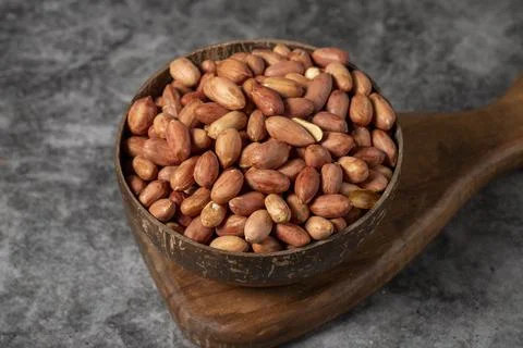 Peanuts on dark background. Peanuts in a coconut bowl. Studio shoot. close up Stock Photos