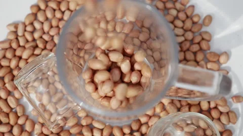 Peanuts fall from the top into a glass plate Stock Footage 139746564