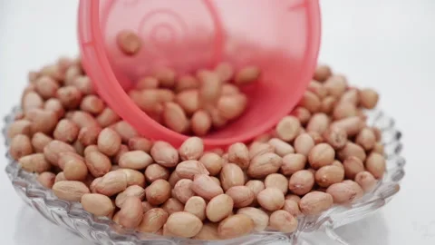 Peanuts fall from the top into a red bowl Video stock 139746321
