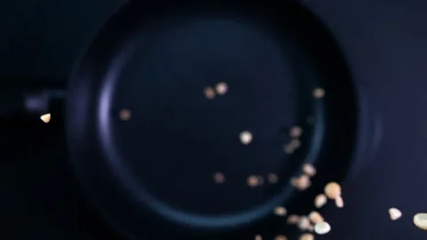 Peanuts falling into a frying pan in slow motion Stock Footage 280685346