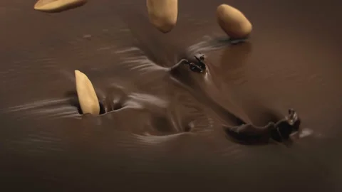Peanuts Falling Into Liquid Chocolate in 4K Super slow motion Stock Footage 143465401