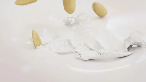 Peanuts Falling Into Milk in 4K slow motion Stock Footage 143484619