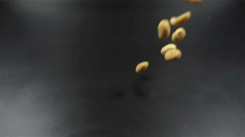 Peanuts falling in slow motion on black background Stock Footage 104576321