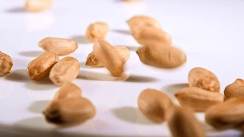 Peanuts falling on white rotate table Stock Footage 122010960