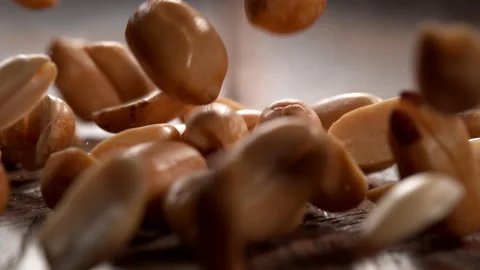 Peanuts falling onto wooden surface in slow motion.  Shot with Phantom Flex 4K Stock Footage 162864152