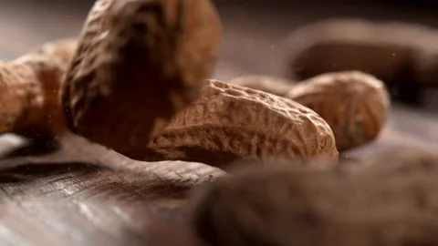 Peanuts falling onto wooden surface in slow motion.  Shot with Phantom Flex 4K Vídeos de archivo 162864175