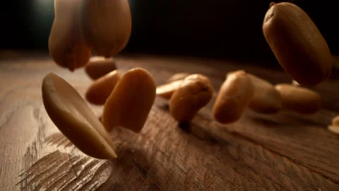 Peanuts falling onto wooden surface in slow motion.  Shot with Phantom Flex 4K Stock Footage 162864449