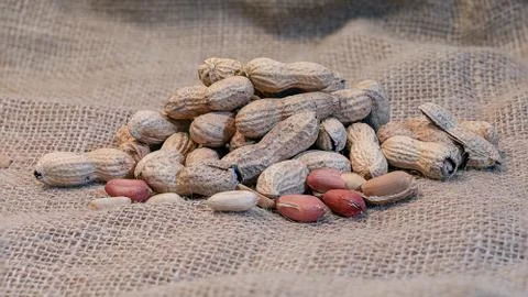 Peanuts in the foreground on rustic underground. Stock-Fotos