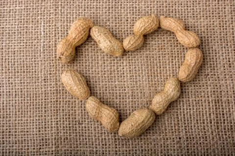 Peanuts form a heart shape on canvas Foto stock