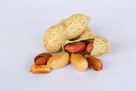 Peanuts isolated on white background . Two kernels are already unpacked. One  Stock Photos