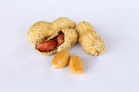 Peanuts isolated on white background . Two kernels are already unpacked. One  Stock Photos