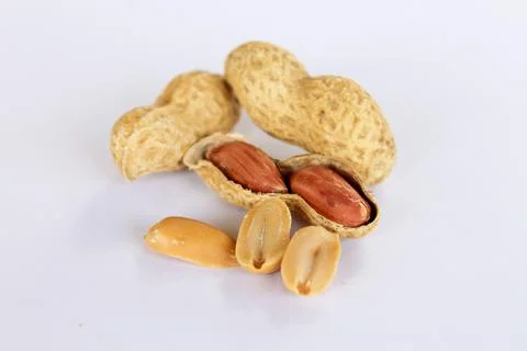 Peanuts isolated on white background . Two kernels are already unpacked. One  Stock Photos
