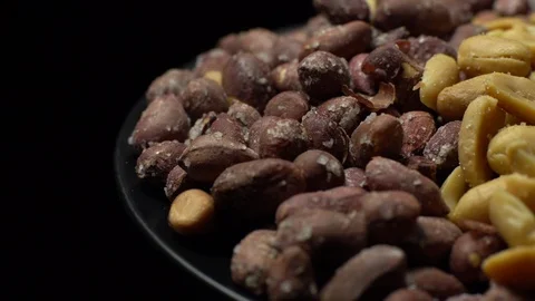 Peanuts. Mixed Peanuts in rotation. Snack closeup. black background. Stock Footage 102291662