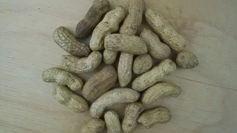 Peanuts in nutshell turning on wooden background top close view. Stock Footage 167085685