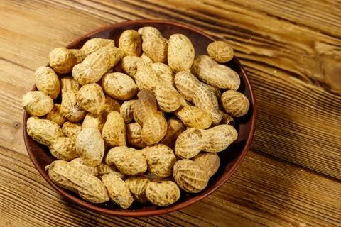 Peanuts in nutshell on a wooden table Stock Photos
