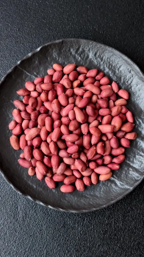 Peanuts or peeled graundnut in a bowl on a dark concrete background Stock Footage 305679244