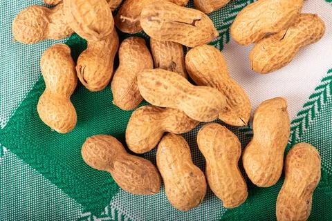 Peanuts, portion of peanuts in shell on a green and white checkered tablecl.. Foto stock