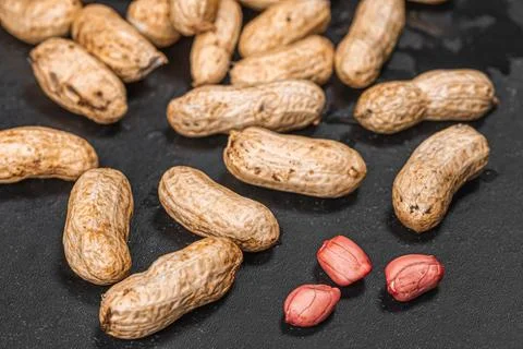 Peanuts raw in shell and peeled peanut kernels Stock Photos