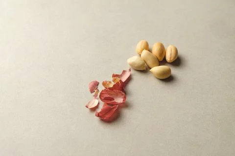 Peanuts scattered on a smooth surface with delicate shells beside them 库存照片