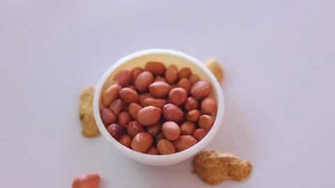 Peanuts seeds on white bowl with shell, Peanuts seeds or pills on white backg Video stock 153980389