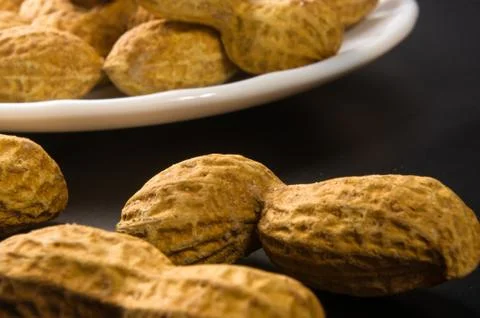 Peanuts in shell on dark background, close up Stock Photos