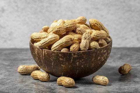 Peanuts in shell on dark background. Peanuts in a coconut bowl. close up Stock Photos