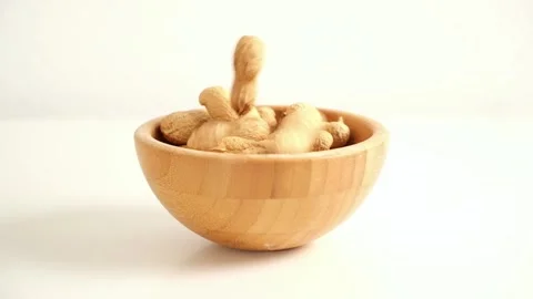 Peanuts in a shell fall into a bowl on a white background. Healthy food. Stock Footage 241927469