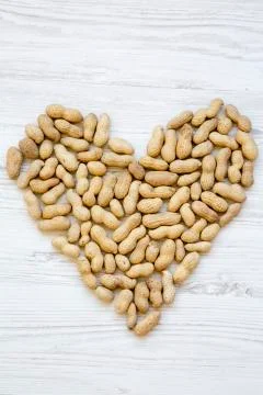 Peanuts in a shell. Heart shape, top view. Flat lay. From above. Stockfoto's