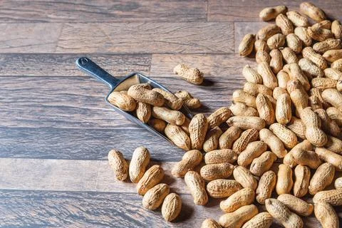 Peanuts in shell on wooden floor Stock Photos