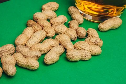 Peanuts in shells snack Green background snack for alcohol Stock Photos