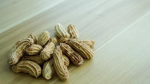 Peanuts in shells on wood background Stock Photos